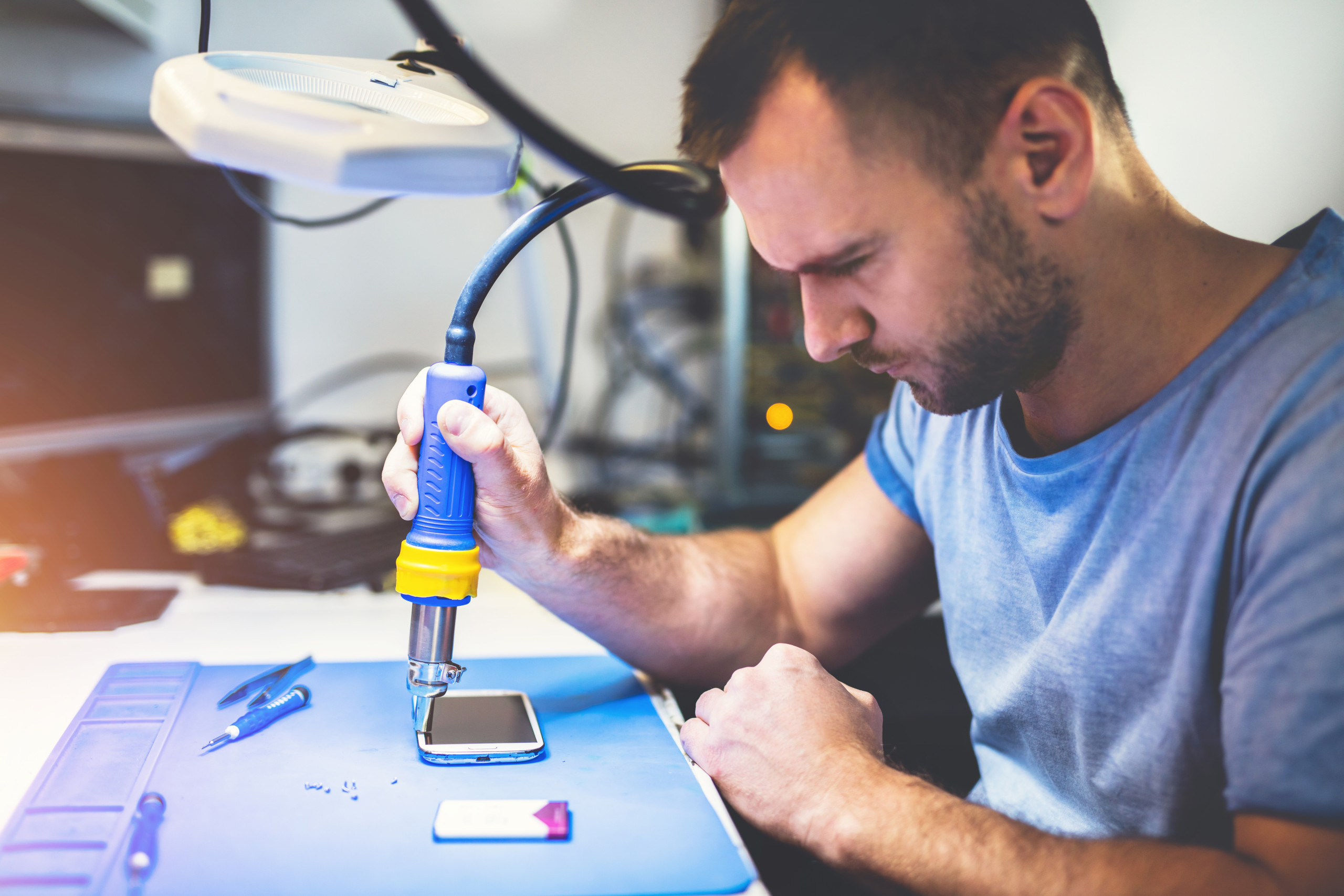 man repairing smartphone at workplace to resolve common Issues