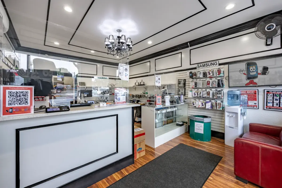 Inside a One Hour Device Repair store: the walk-in counter, display cases and waiting chair
