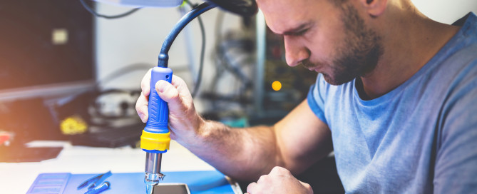 man repairing smartphone at workplace to resolve common Issues